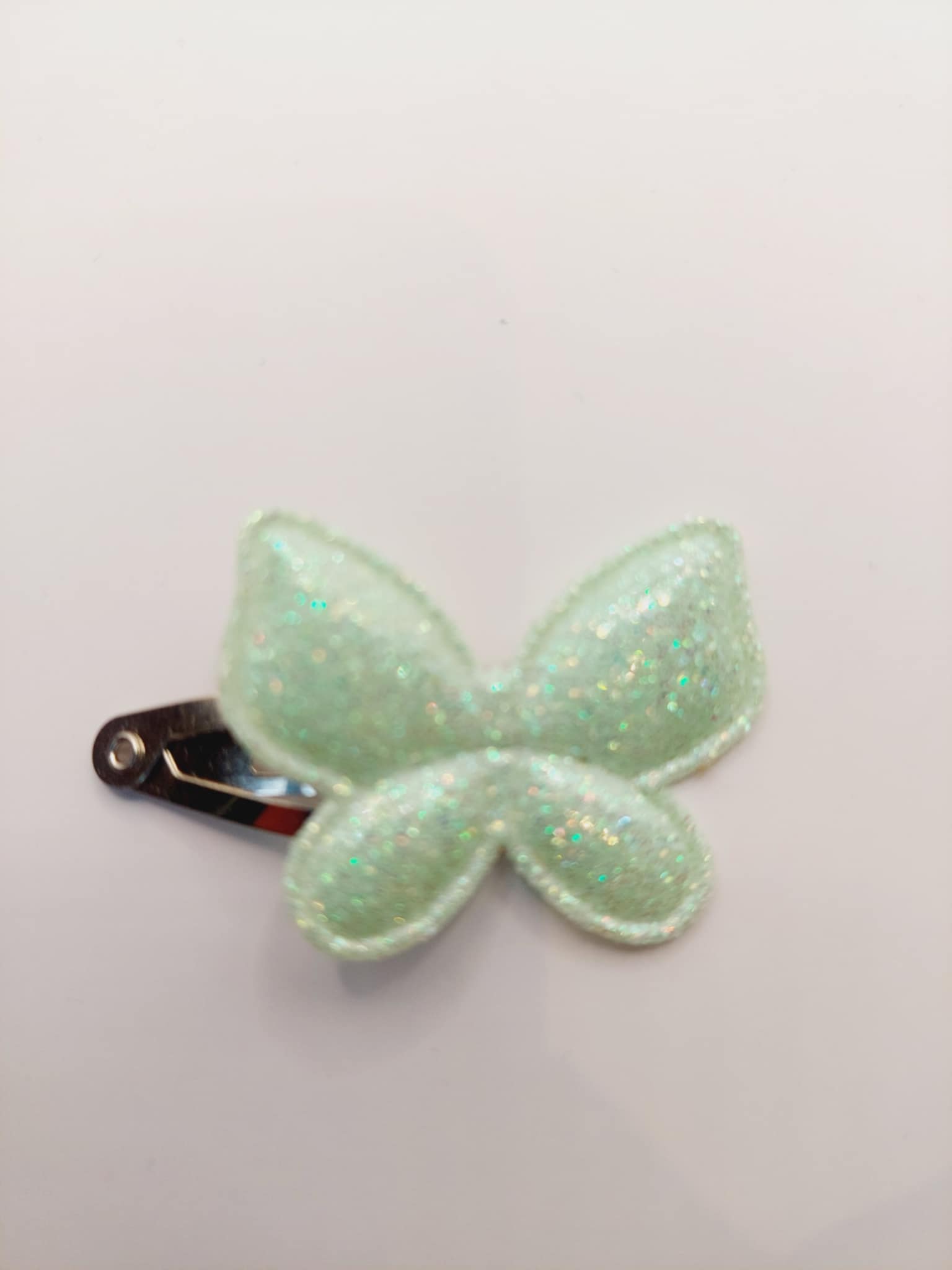 Haarclip van 3 cm met een mint groene vlinder met gliiter