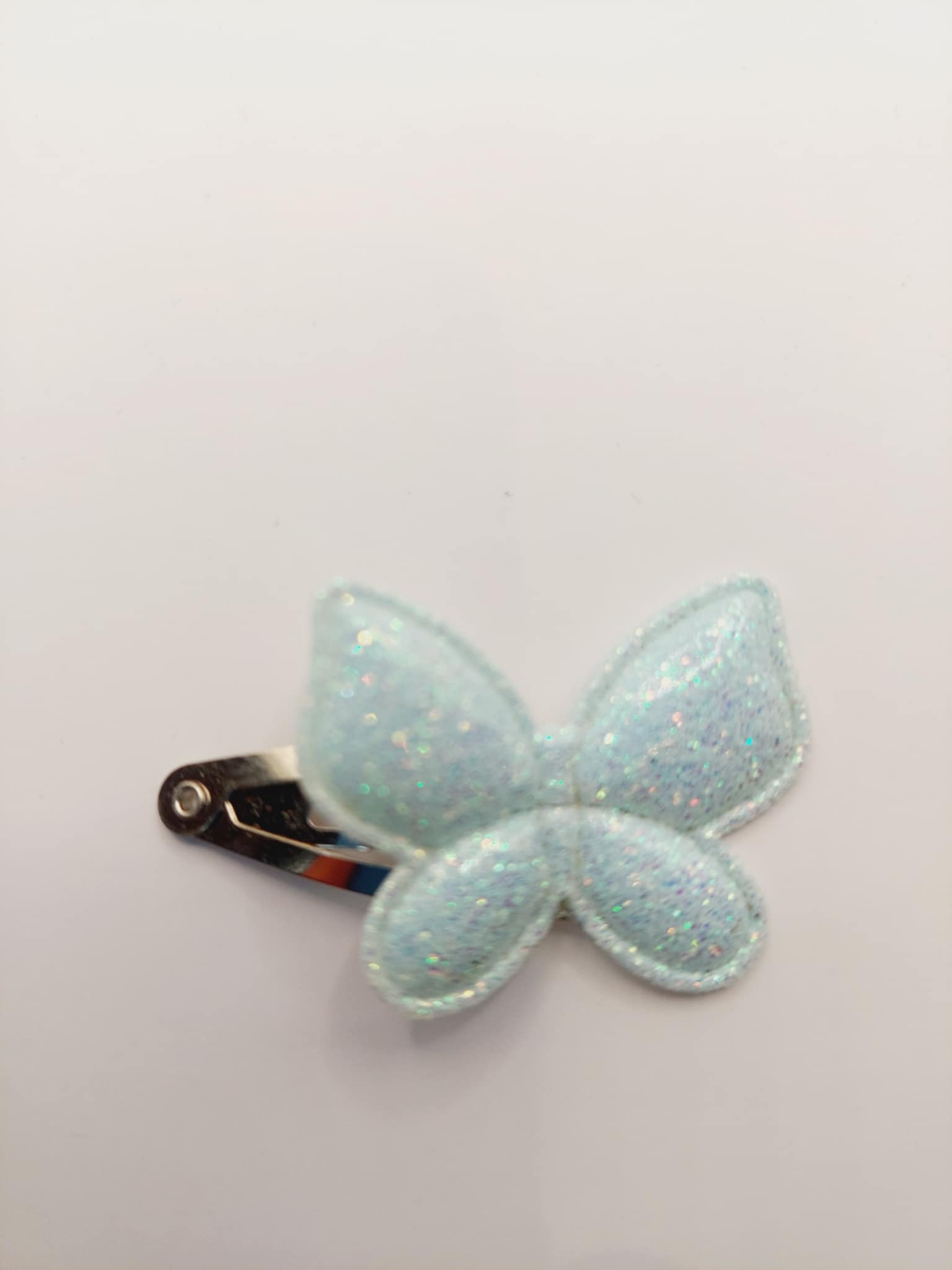 Haarclip van 3 cm met een licht blauwe vlinder met gliiter