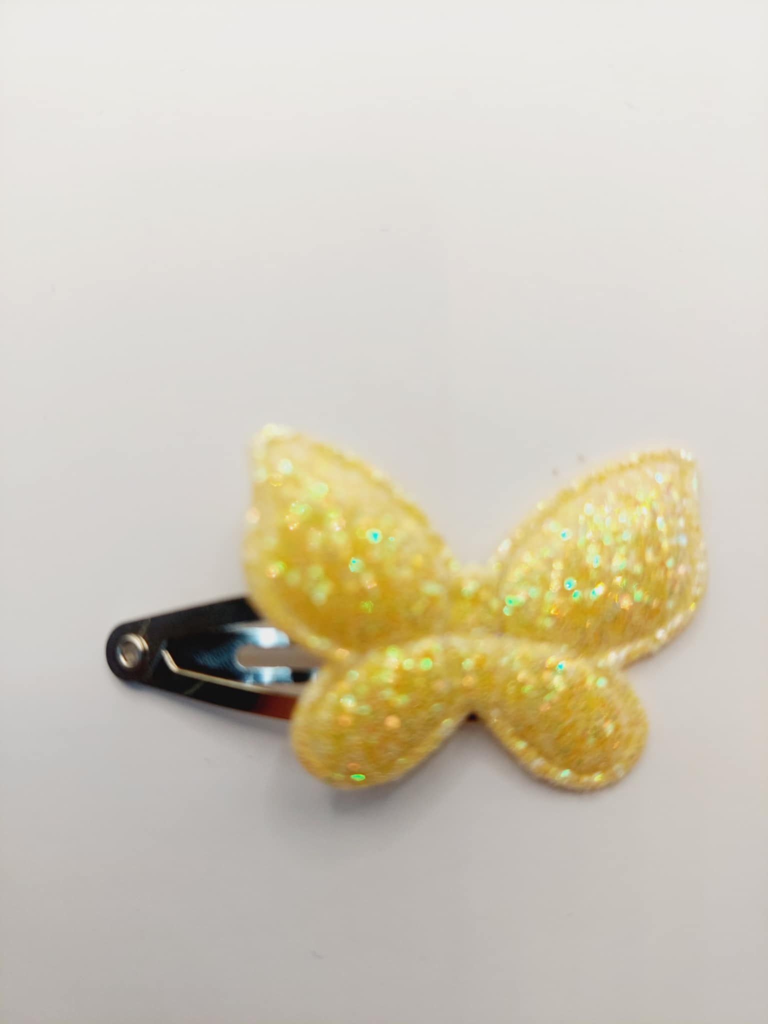 Haarclip van 3 cm met een goud / geel vlinder met gliiter