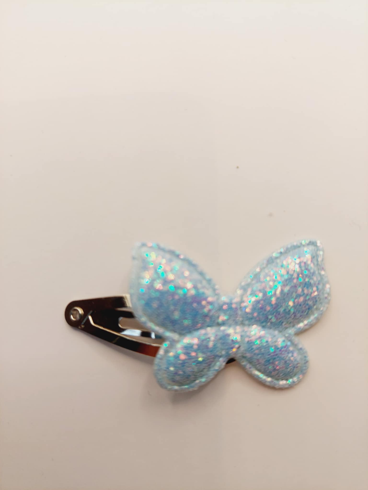 Haarclip van 3 cm met een licht blauw vlinder met gliiter