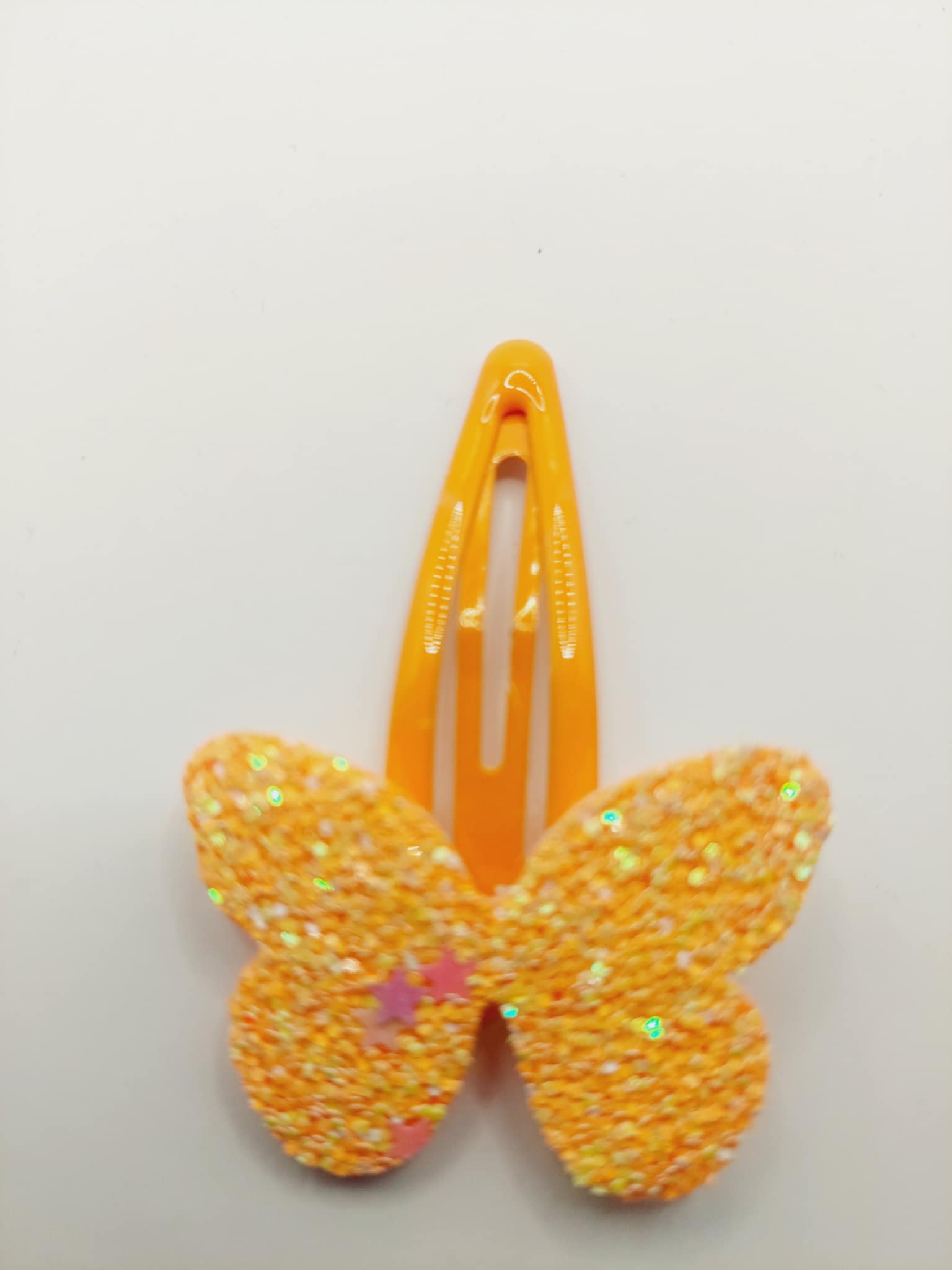 Haarclip met een rubber coating met een oranje vlinder met glitter