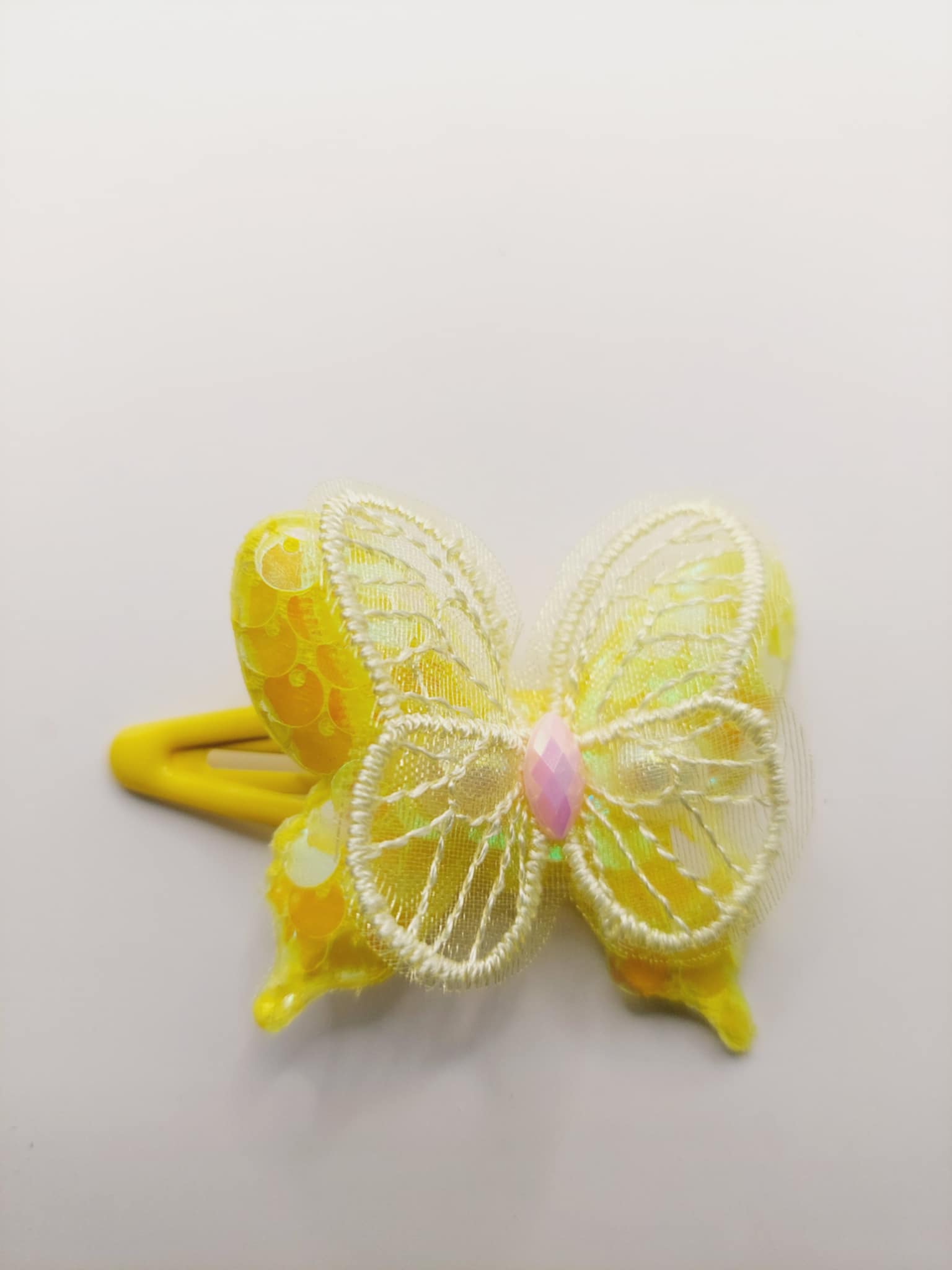 Haarclip met een rubber coating met een geel vlinder met glitter en pailletjes