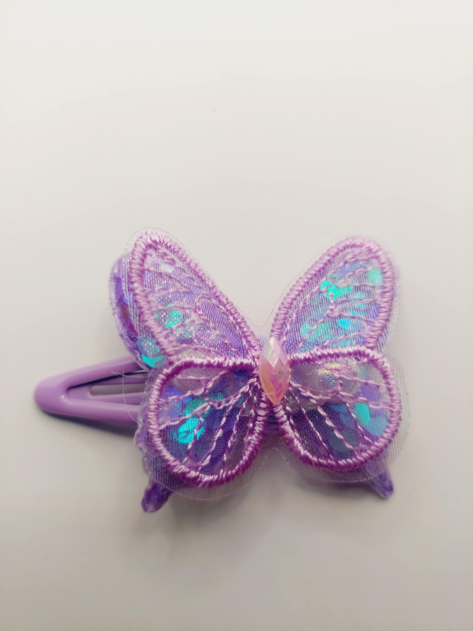 Haarclip met een rubber coating met een paars vlinder met glitter en pailletjes