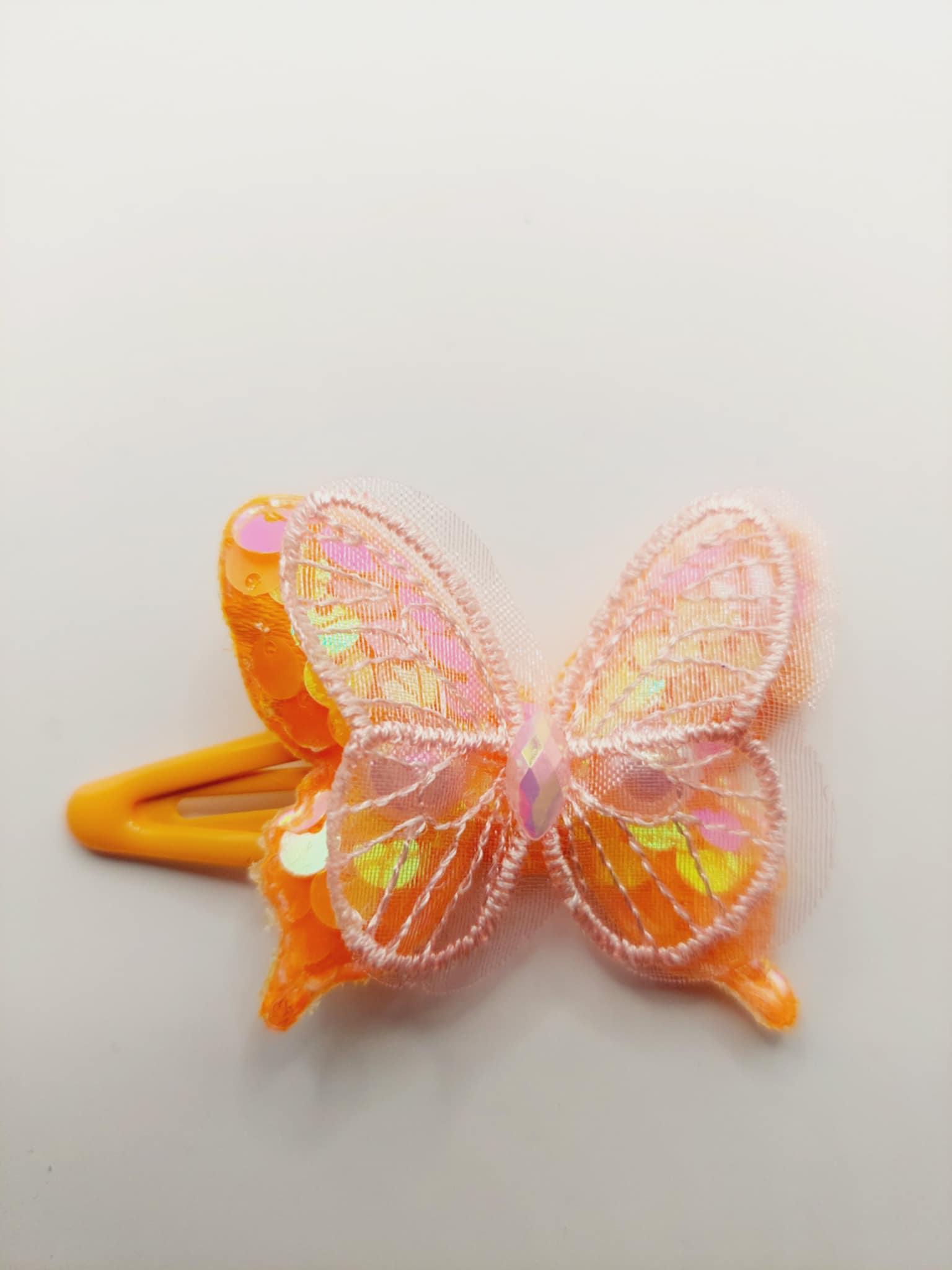 Haarclip met een rubber coating met een oranje vlinder met glitter en pailletjes